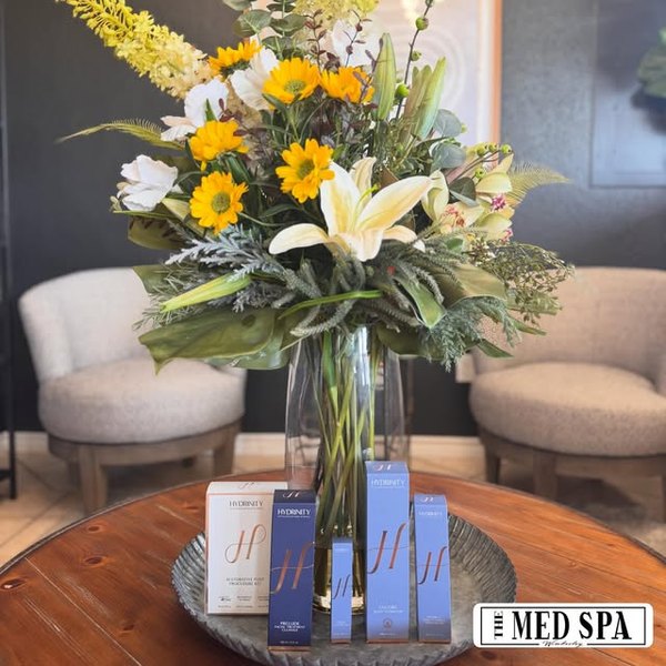 Hydrinity skincare beside a vase of flowers in the waiting area
